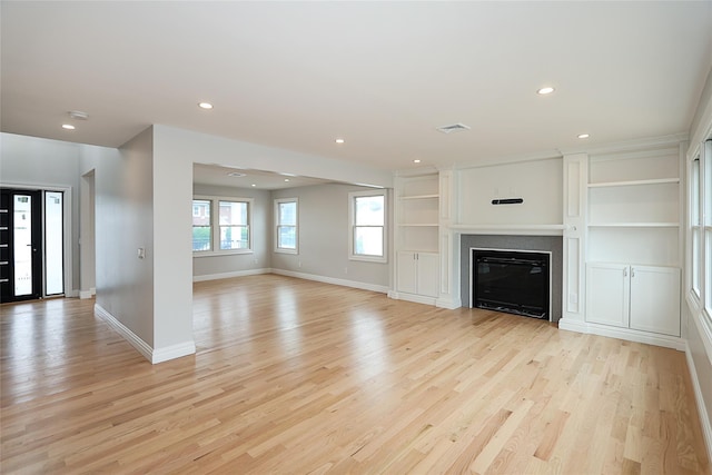 482 S 5th St, Lindenhurst, NY 11757 - unfurnished living room featuring light wood-style floors, recessed lighting, baseboards, and a glass covered fireplace