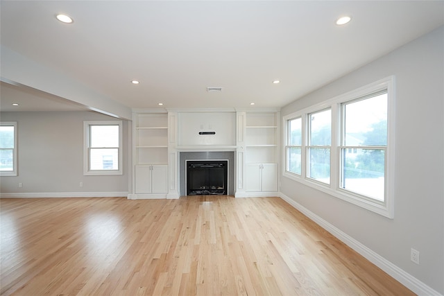 482 S 5th St, Lindenhurst, NY 11757 - unfurnished living room with baseboards, healthy amount of natural light, a fireplace, light wood-type flooring, and recessed lighting