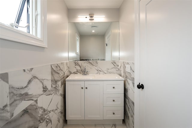 482 S 5th St, Lindenhurst, NY 11757 - bathroom with tile walls, marble finish floors, vanity, and a wainscoted wall
