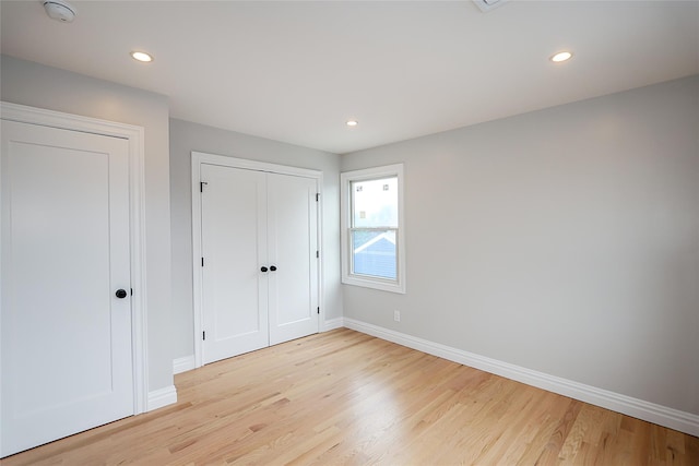482 S 5th St, Lindenhurst, NY 11757 - unfurnished bedroom featuring light wood-style floors, baseboards, recessed lighting, and a closet