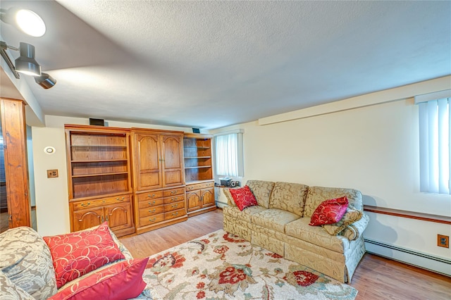 50 W Hampton Rd, Lindenhurst, NY 11747 - living room featuring baseboard heating, light wood-type flooring, and a textured ceiling