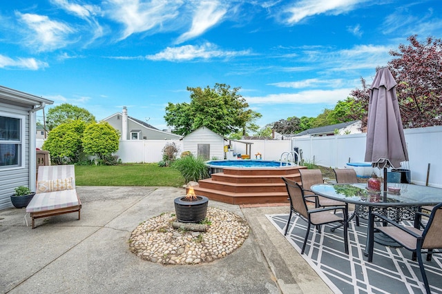 56 15th St, West Babylon, NY 11704 - fenced backyard featuring a patio area, outdoor dining space, an outdoor fire pit, and a storage unit