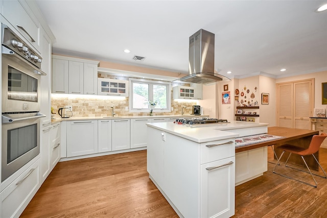 1608 Union Ave Unit 1608, Hewlett, NY 11557 - kitchen with island exhaust hood, appliances with stainless steel finishes, backsplash, glass insert cabinets, and a sink