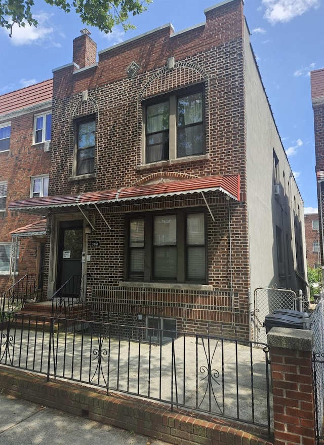 31-61 43rd St, Astoria, NY 11103 - view of front facade with brick siding and a fenced front yard