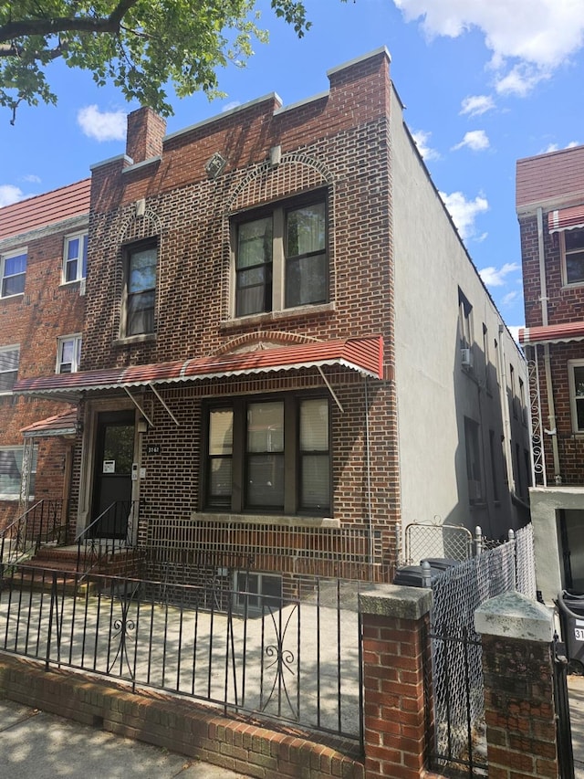 31-61 43rd St, Astoria, NY 11103 - view of front facade with a fenced front yard and brick siding
