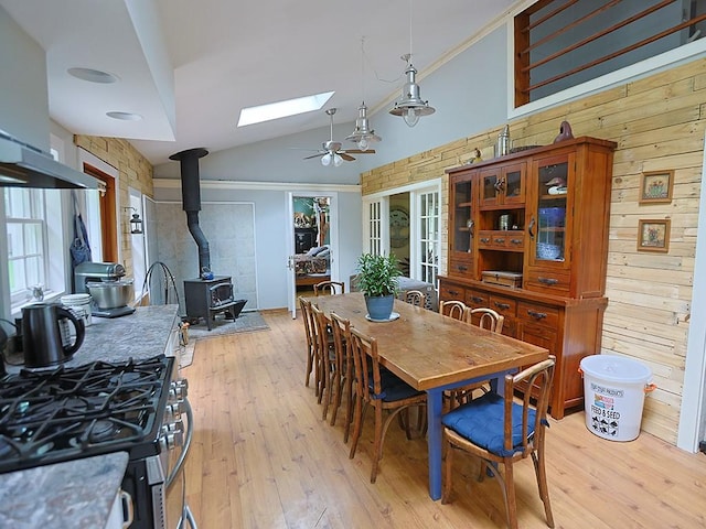 120 Spring Glen Rd, Mountain Dale, NY 12763 - dining room with a wood stove, a skylight, light wood-style floors, vaulted ceiling, and wood walls