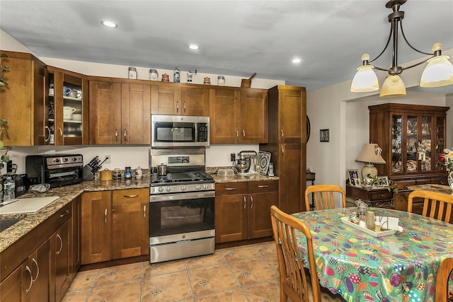 1150 Langdon St, Franklin Square, NY 11010 - kitchen with stainless steel appliances, light tile patterned floors, dark stone countertops, recessed lighting, and pendant lighting