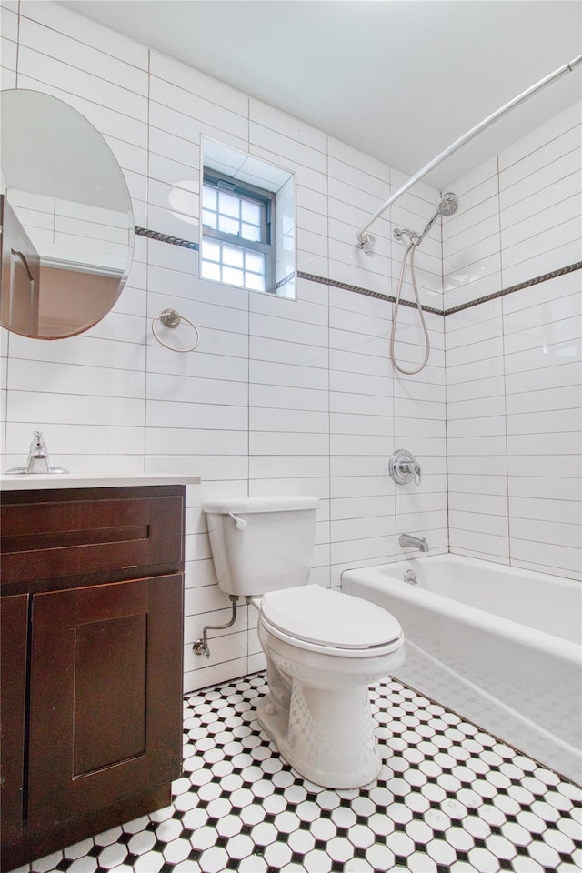 151 Noll St, Brooklyn, NY 11206 - bathroom with tile patterned floors, toilet, tile walls, vanity, and washtub / shower combination