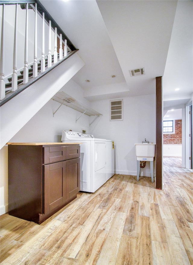 151 Noll St, Brooklyn, NY 11206 - laundry area featuring washing machine and dryer, light wood-style floors, baseboards, and a sink