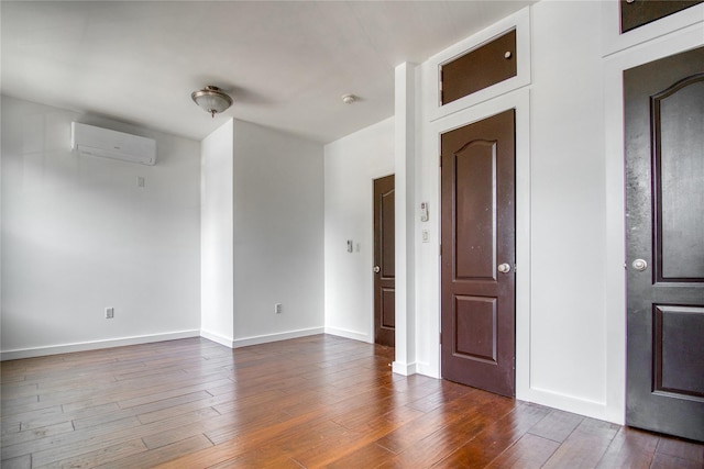 151 Noll St, Brooklyn, NY 11206 - unfurnished room featuring a wall unit AC, dark wood-style floors, and baseboards