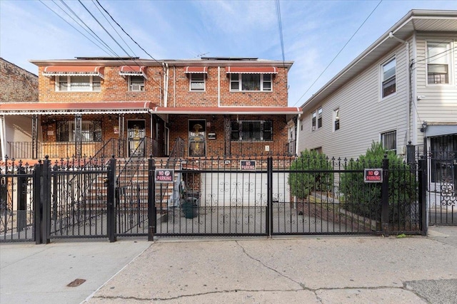 2722 Barnes Ave, Bronx, NY 10467 - townhome / multi-family property with brick siding, a fenced front yard, covered porch, and a gate