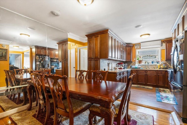 2722 Barnes Ave, Bronx, NY 10467 - dining area with an AC wall unit, light wood-type flooring, and ornamental molding