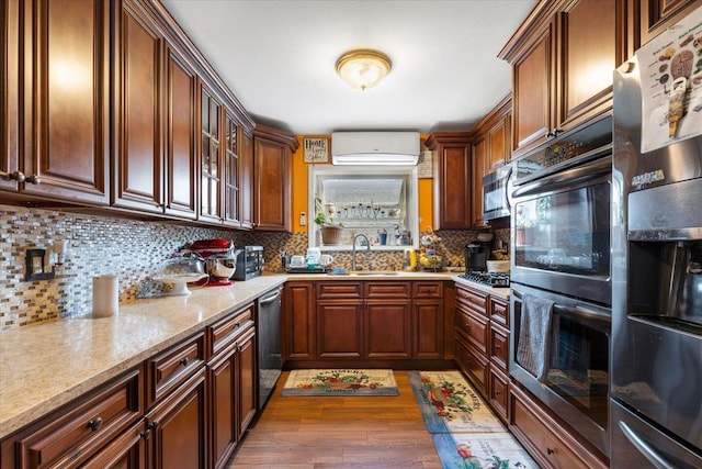 2722 Barnes Ave, Bronx, NY 10467 - kitchen featuring appliances with stainless steel finishes, wood finished floors, a sink, a wall mounted air conditioner, and decorative backsplash