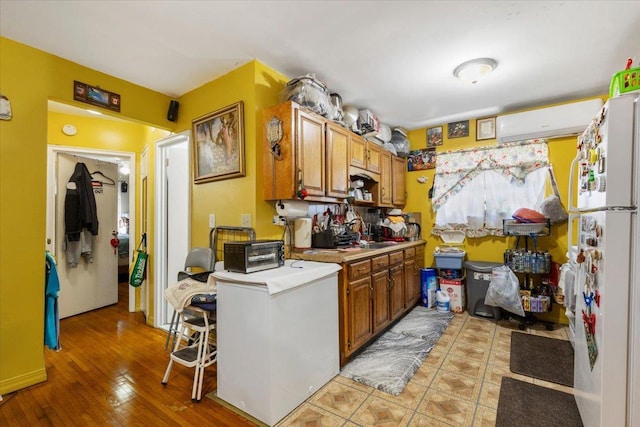 2722 Barnes Ave, Bronx, NY 10467 - kitchen with freestanding refrigerator, light countertops, brown cabinets, a sink, and light wood-type flooring