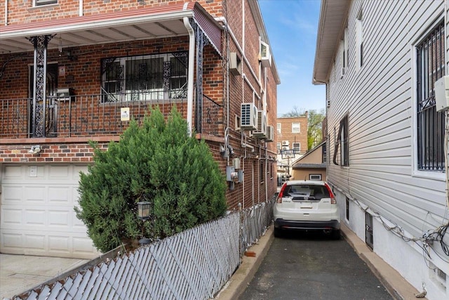 2722 Barnes Ave, Bronx, NY 10467 - view of home's exterior with brick siding, a garage, and asphalt driveway