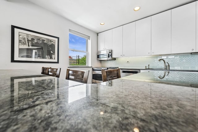 162-41 Powells Cove Blvd Unit 4G, Beechhurst, NY 11357 - kitchen with stainless steel appliances, a sink, decorative backsplash, dark stone counters, and recessed lighting