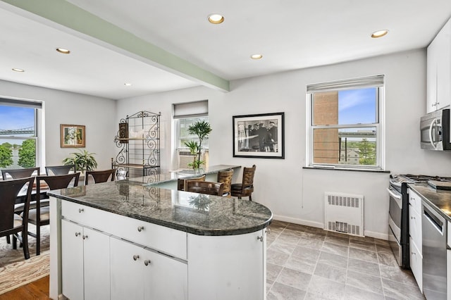 162-41 Powells Cove Blvd Unit 4G, Beechhurst, NY 11357 - kitchen featuring radiator, appliances with stainless steel finishes, recessed lighting, baseboards, and white cabinetry