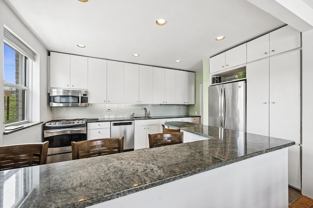 162-41 Powells Cove Blvd Unit 4G, Beechhurst, NY 11357 - kitchen with appliances with stainless steel finishes, a sink, tasteful backsplash, dark stone counters, and white cabinets