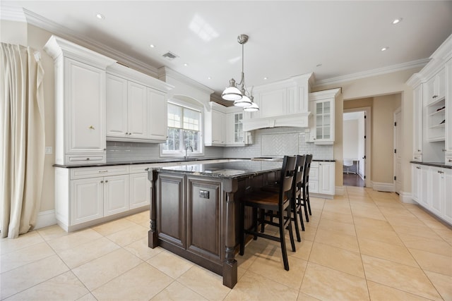 kitchen featuring decorative backsplash, light tile patterned floors, glass insert cabinets, ornamental molding, and white cabinets
