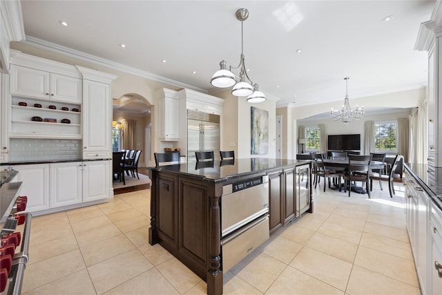 kitchen featuring stainless steel built in fridge, arched walkways, a chandelier, light tile patterned flooring, and crown molding