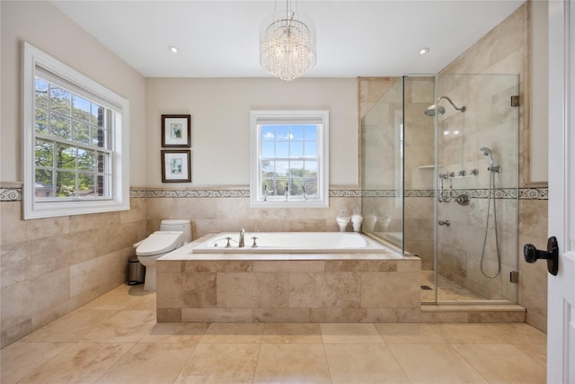 full bathroom with a garden tub, a shower stall, a chandelier, toilet, and wainscoting