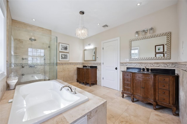bathroom with tile walls, a shower stall, a bath, a chandelier, and tile patterned floors