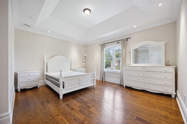 bedroom featuring dark wood-style flooring, a raised ceiling, recessed lighting, ornamental molding, and baseboards