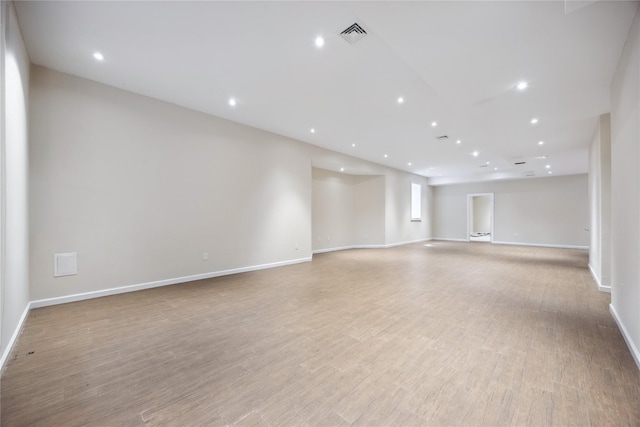 spare room with baseboards, light wood-style flooring, and recessed lighting