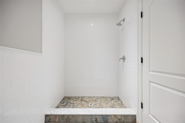 bathroom with a stall shower and tile walls