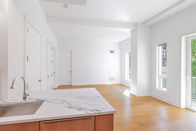 250 E 49th St Unit 5F, New York Manhattan, NY 10017 - kitchen with a sink, light wood-style floors, healthy amount of natural light, and brown cabinetry