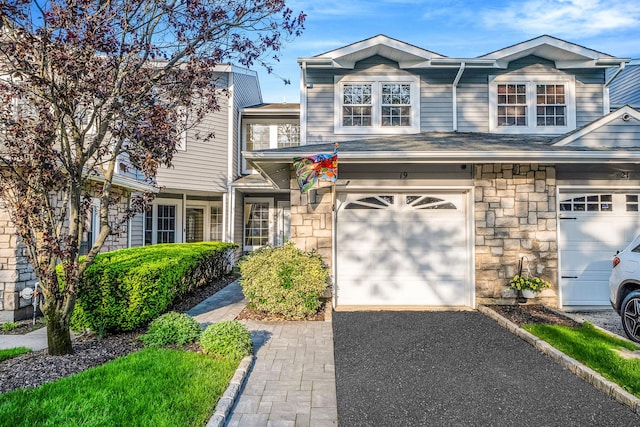 19 Hampshire Ct, Holbrook, NY 11741 - view of front of home with an attached garage, stone siding, and asphalt driveway