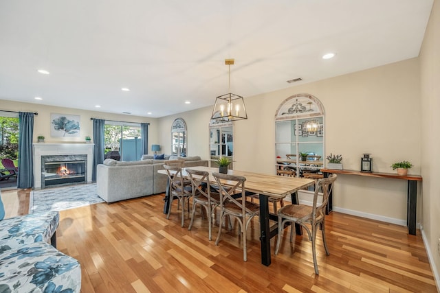 19 Hampshire Ct, Holbrook, NY 11741 - dining space with light wood finished floors, a fireplace, recessed lighting, a chandelier, and baseboards