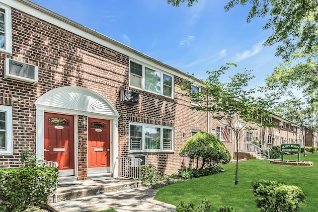 78-07 Springfield Blvd Unit B, Bayside, NY 11364 - view of front of home featuring brick siding, a front lawn, and a wall mounted air conditioner