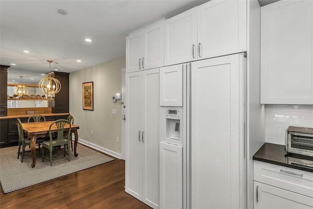 433 Main St Unit 203, Port Washington, NY 11050 - kitchen with dark wood-type flooring, backsplash, recessed lighting, a chandelier, and paneled refrigerator