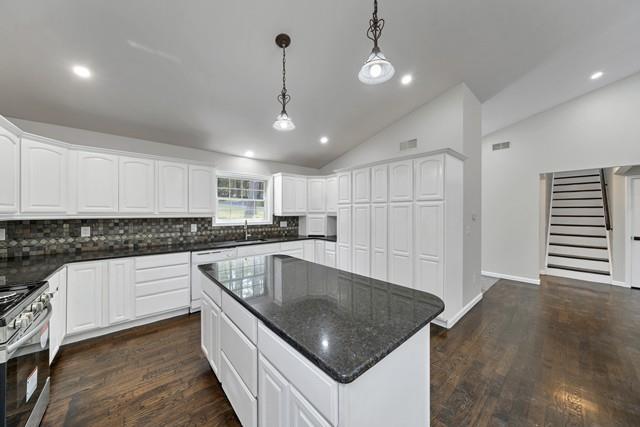 65 Old Cahoonzie Rd, Sparrowbush, NY 12780 - kitchen featuring gas stove, decorative backsplash, vaulted ceiling, a center island, and dark wood-style floors
