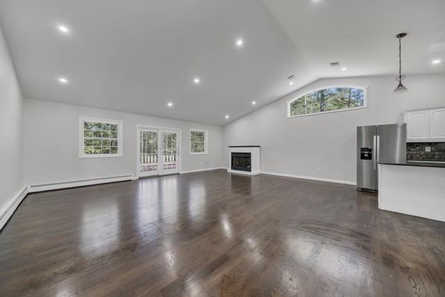 65 Old Cahoonzie Rd, Sparrowbush, NY 12780 - unfurnished living room featuring baseboard heating, dark wood-style flooring, a fireplace, baseboards, and high vaulted ceiling