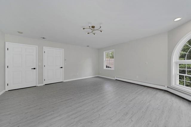 65 Old Cahoonzie Rd, Sparrowbush, NY 12780 - empty room with wood finished floors, baseboards, a baseboard radiator, and a chandelier