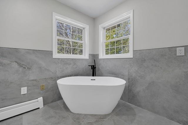 65 Old Cahoonzie Rd, Sparrowbush, NY 12780 - full bath featuring a baseboard radiator, tile walls, a soaking tub, and wainscoting