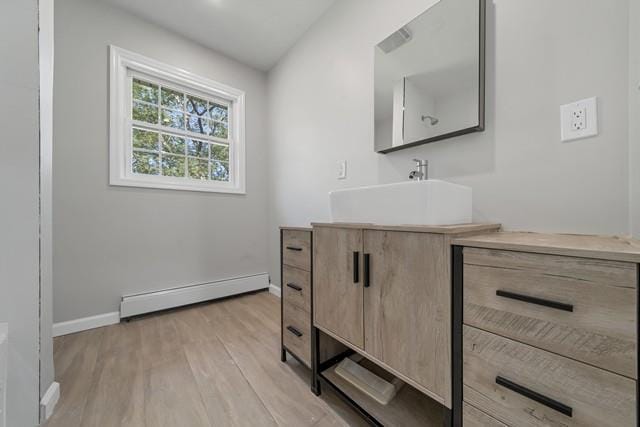 65 Old Cahoonzie Rd, Sparrowbush, NY 12780 - bathroom featuring baseboard heating, baseboards, wood finished floors, and vanity