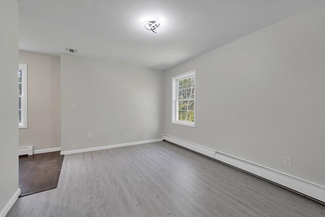 65 Old Cahoonzie Rd, Sparrowbush, NY 12780 - unfurnished room featuring a baseboard heating unit, wood finished floors, and baseboards
