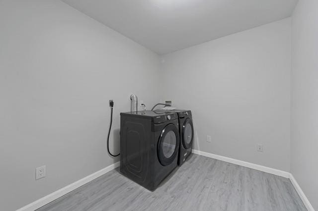 65 Old Cahoonzie Rd, Sparrowbush, NY 12780 - laundry area featuring washer and clothes dryer, light wood finished floors, and baseboards