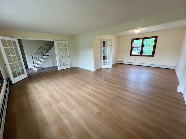 35 Thomas St, Coram, NY 11727 - unfurnished living room with a baseboard heating unit, french doors, wood finished floors, and stairway
