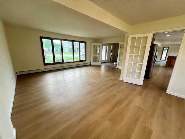35 Thomas St, Coram, NY 11727 - unfurnished living room featuring a baseboard heating unit, baseboards, and wood finished floors