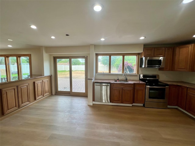 35 Thomas St, Coram, NY 11727 - kitchen with appliances with stainless steel finishes, recessed lighting, brown cabinetry, a sink, and light wood finished floors