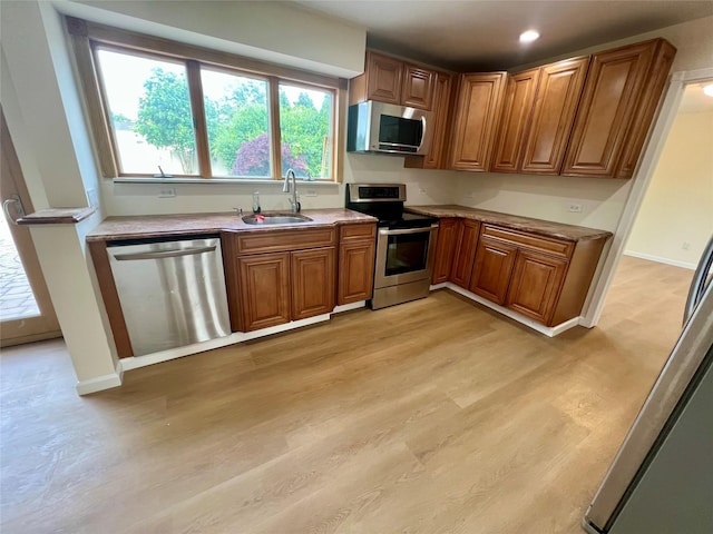 35 Thomas St, Coram, NY 11727 - kitchen featuring appliances with stainless steel finishes, a sink, brown cabinets, light wood-type flooring, and recessed lighting