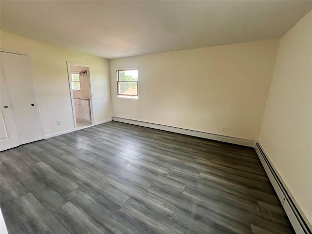 35 Thomas St, Coram, NY 11727 - unfurnished bedroom featuring a baseboard heating unit, dark wood-type flooring, baseboards, and connected bathroom