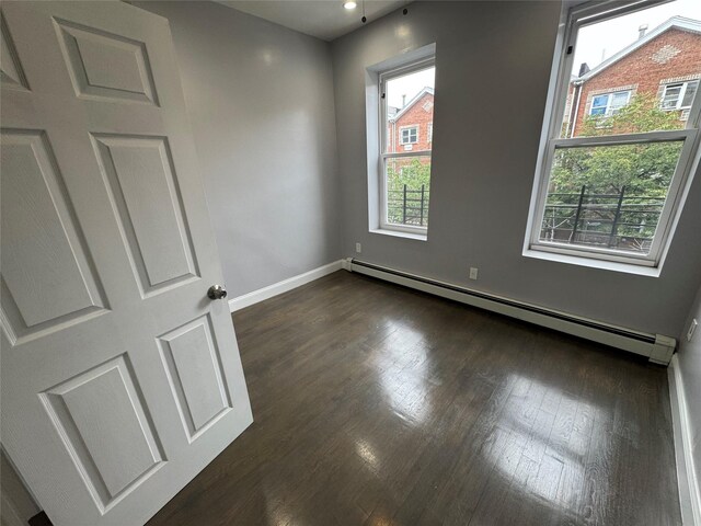 579 Van Siclen Ave, Brooklyn, NY 11207 - unfurnished room featuring a baseboard heating unit, dark wood-style floors, baseboards, and recessed lighting
