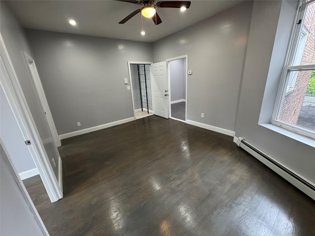 579 Van Siclen Ave, Brooklyn, NY 11207 - unfurnished bedroom with a baseboard heating unit, baseboards, dark wood finished floors, and a ceiling fan