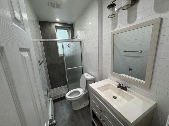 579 Van Siclen Ave, Brooklyn, NY 11207 - bathroom featuring tile walls, toilet, a shower stall, and vanity