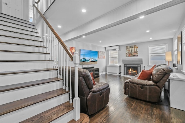 269 Hayward St, Yonkers, NY 10704 - living room featuring an AC wall unit, a warm lit fireplace, wood finished floors, stairway, and recessed lighting